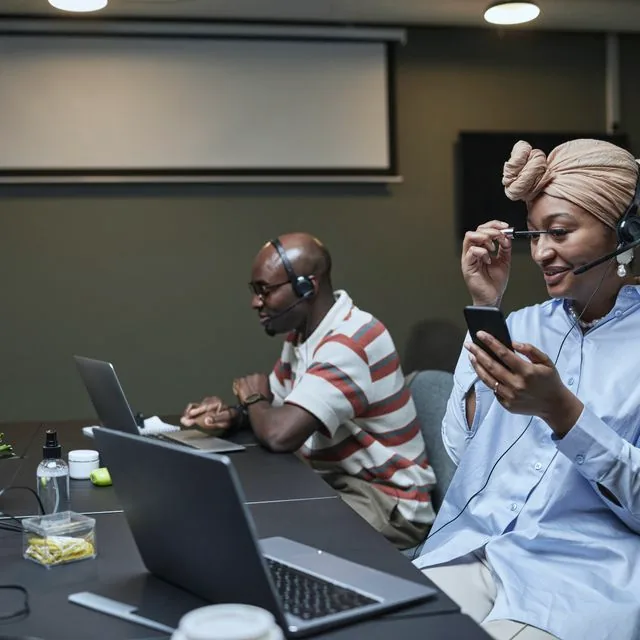 Équipe helpdesk au travail avec casques et ordinateurs portables