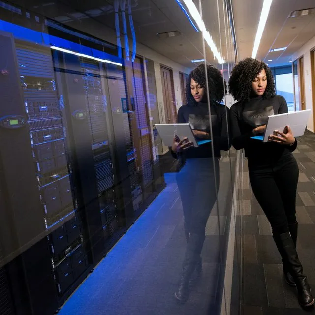 Ingénieure avec un ordinateur portable dans un datacenter cloud